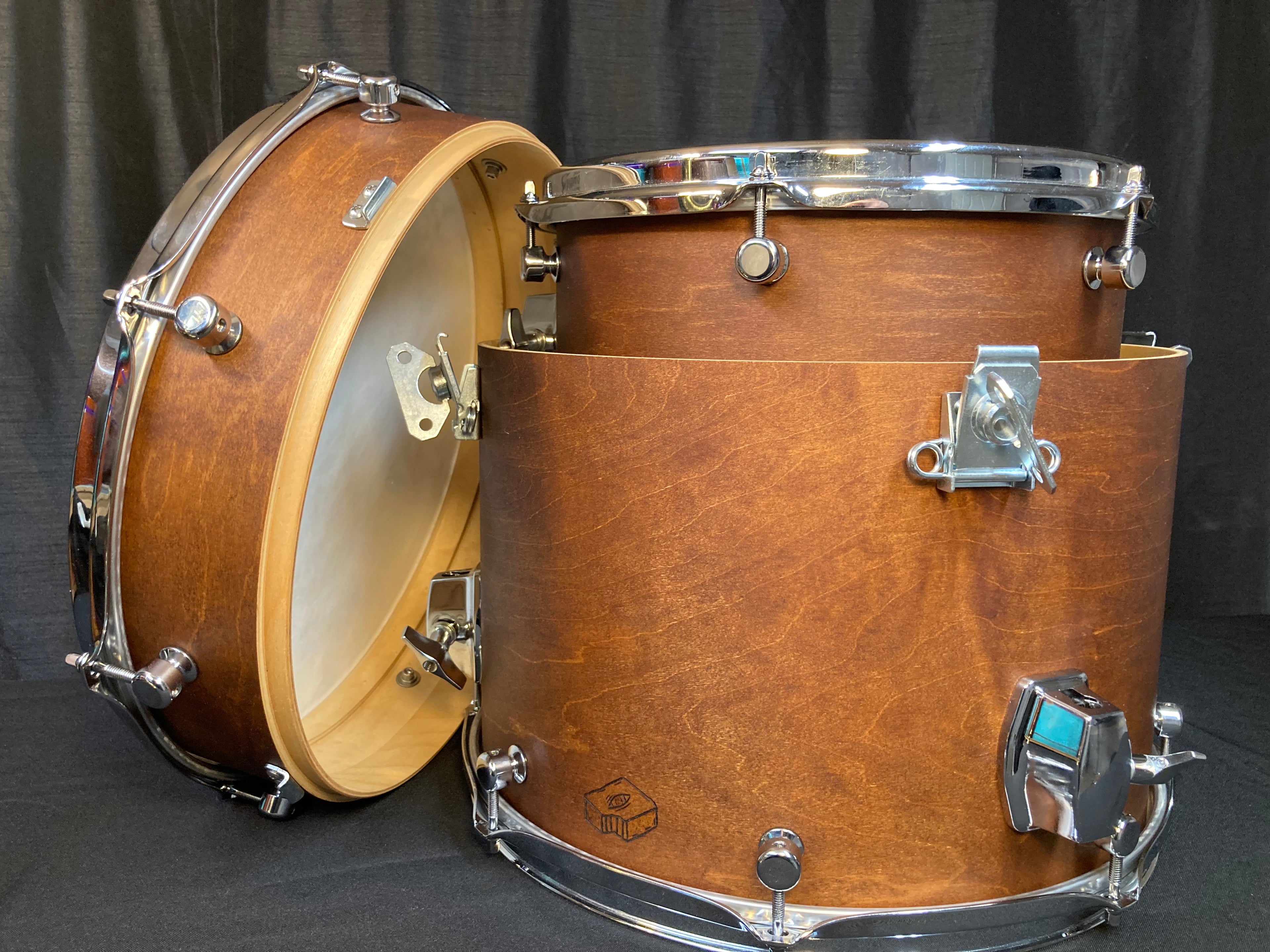 Nesting Drum Kit with one shell nested in another with a maple brown wood dye