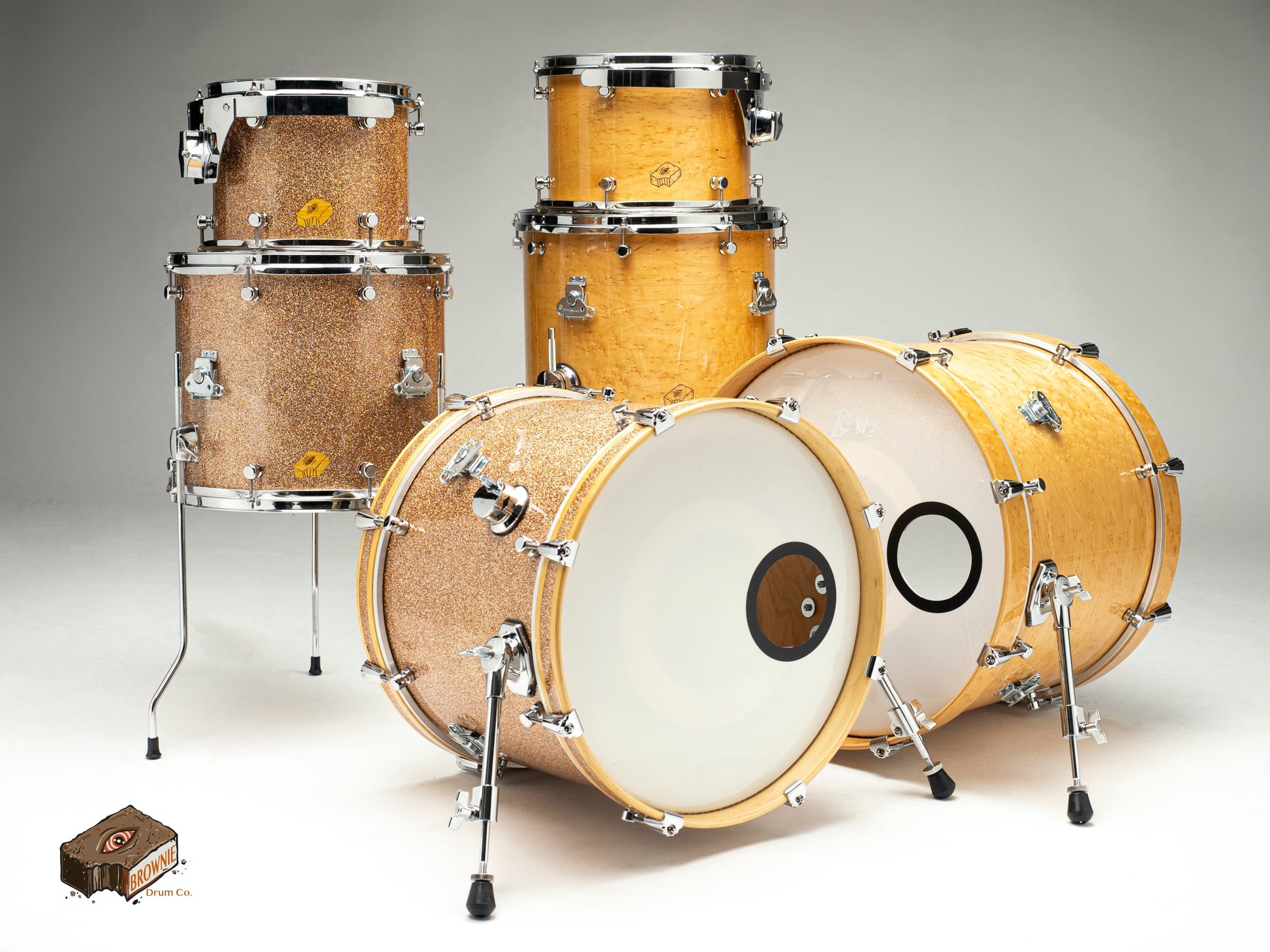 Hand made Nesting Drum Sets shown in a metal flake and a natural maple finish