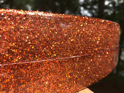 closeup view of a pair of bass drum hoops with orange sparkle finish