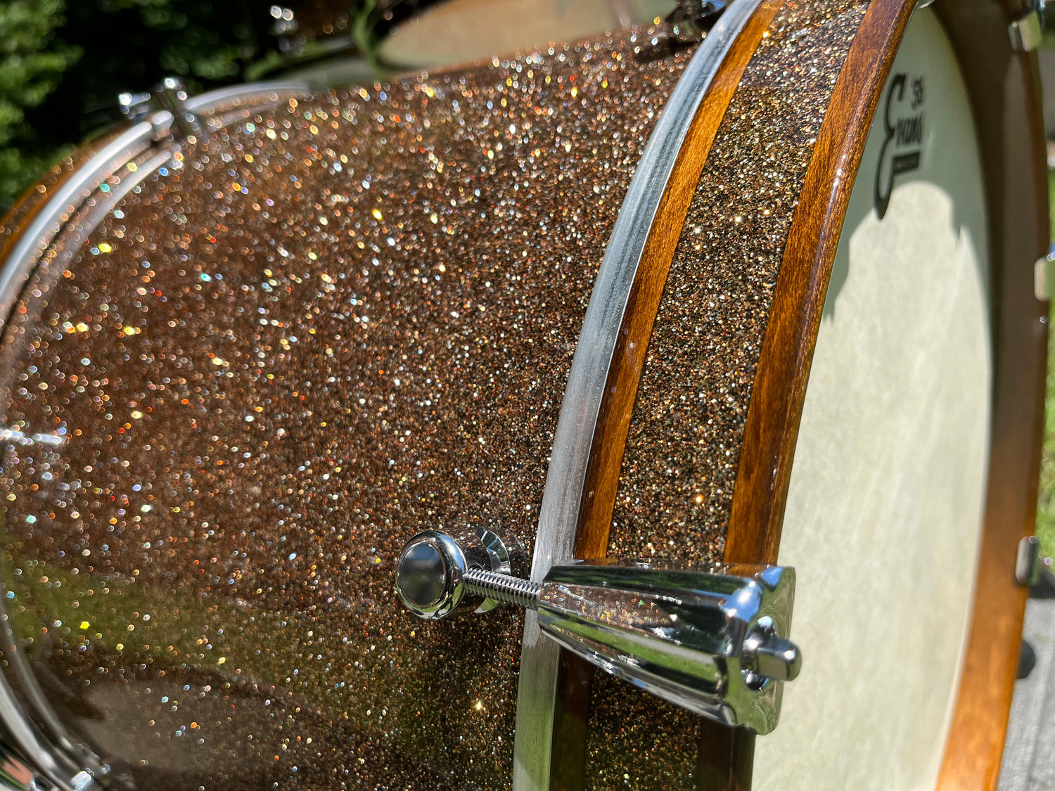 Custom bass drum with metal flake finish and brown accented bass drum hoops